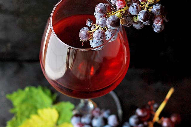 vaso de vino tinto y uvas 